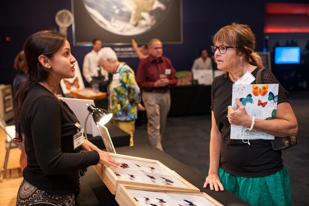 visitor learns about butterflies from a researcher