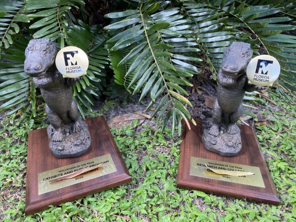 Two trophies for the volunteers of the year. Each trophy is a gator standing on its back legs holding the FM logo.