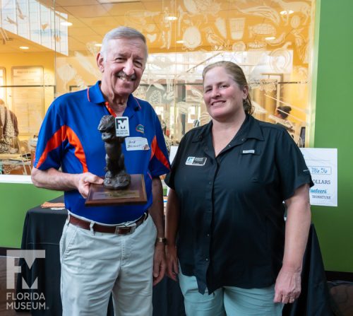 Research and Collections Volunteer of the Year, Bob Belmont holding his gator volunteer of the year trophy with his supervisor Debbie Lott.