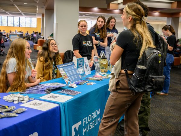 Anna Mavrodieva and Janelle Penas speaks with UF Students at the Florida Museum on the Go table