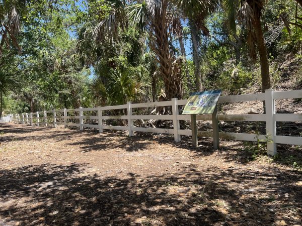 trail with white fence and display sign