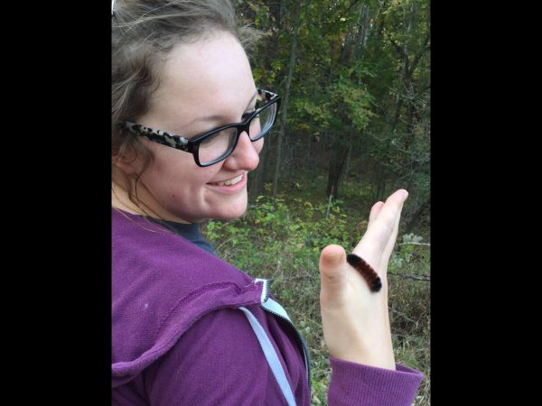 Picture of a woman holding a caterpillar.